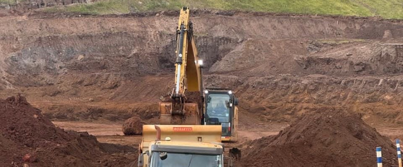 Escavadeira carrega caminhão fora de estrada em cava de mina de ferro no Quadrilátero Ferrífero